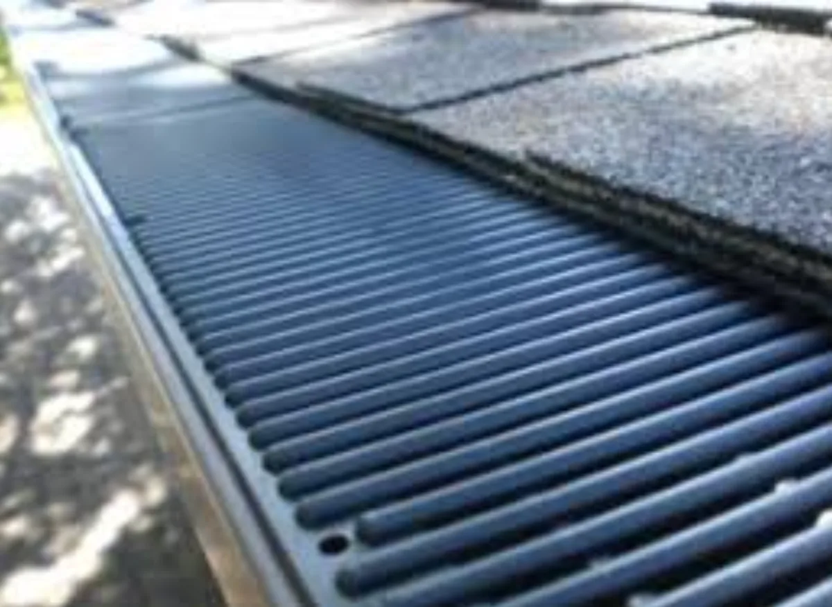 Close up of a gutter guard installed under the edge of a shingle roof