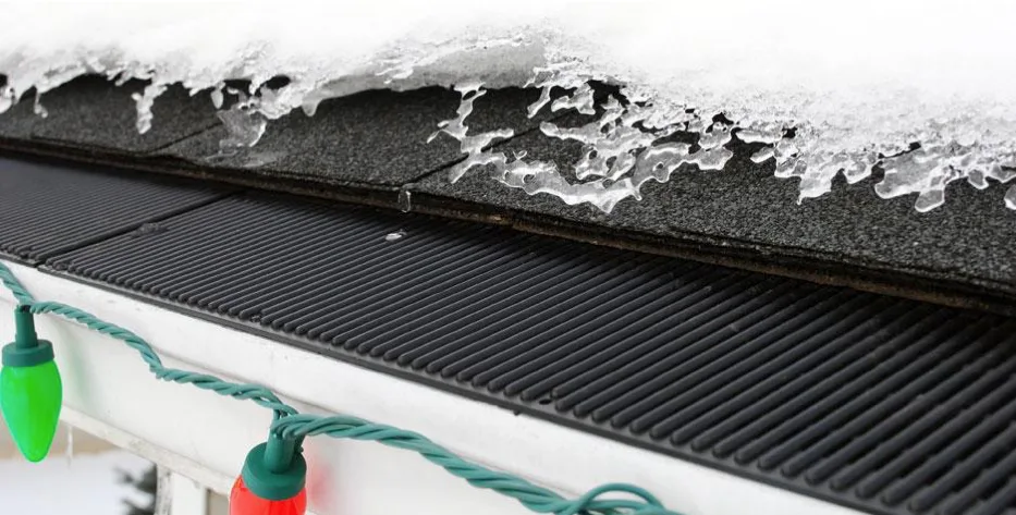 Gutter guard holding its shape under melting ice and snow at the edge of a roof