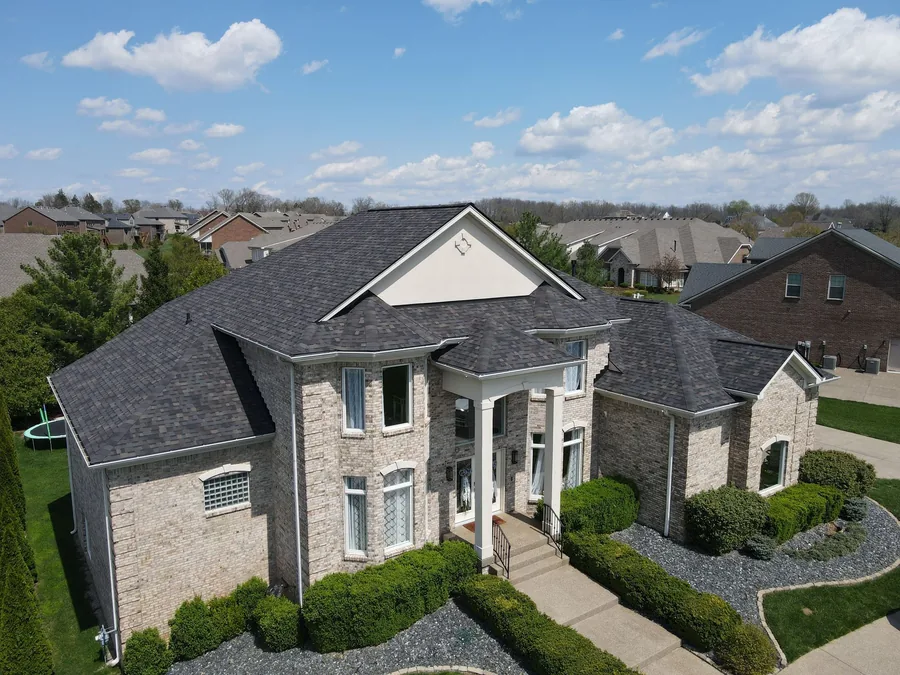 Aerial view of a light brick Louisville home with a brand new shingle roof