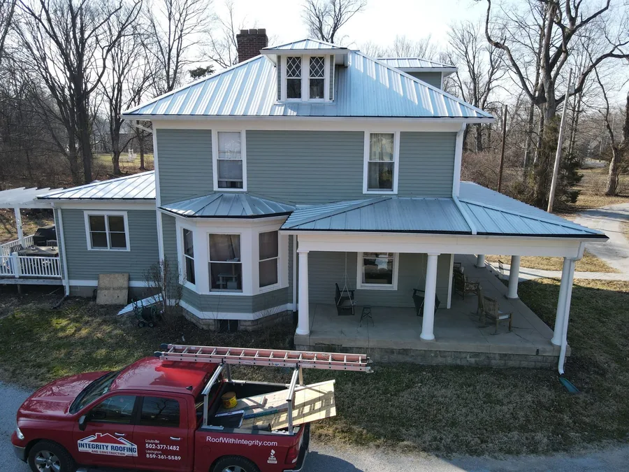 Aerial view of a farmhouse with a new metal roof