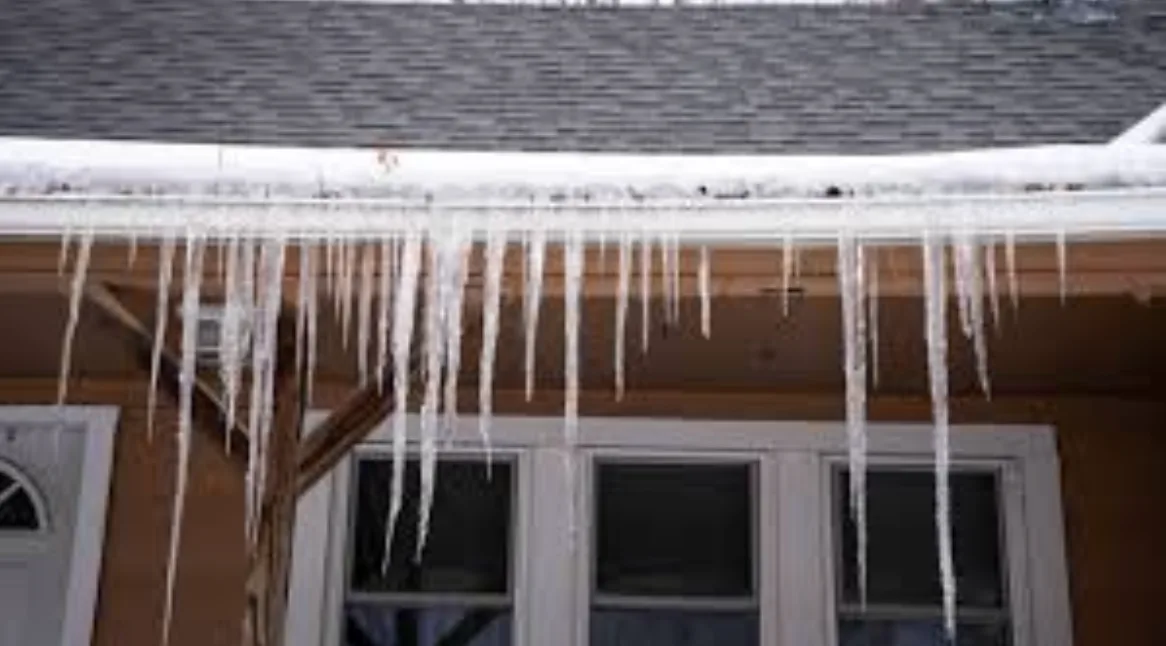 Icicles hanging from a gutter above the windows of a home