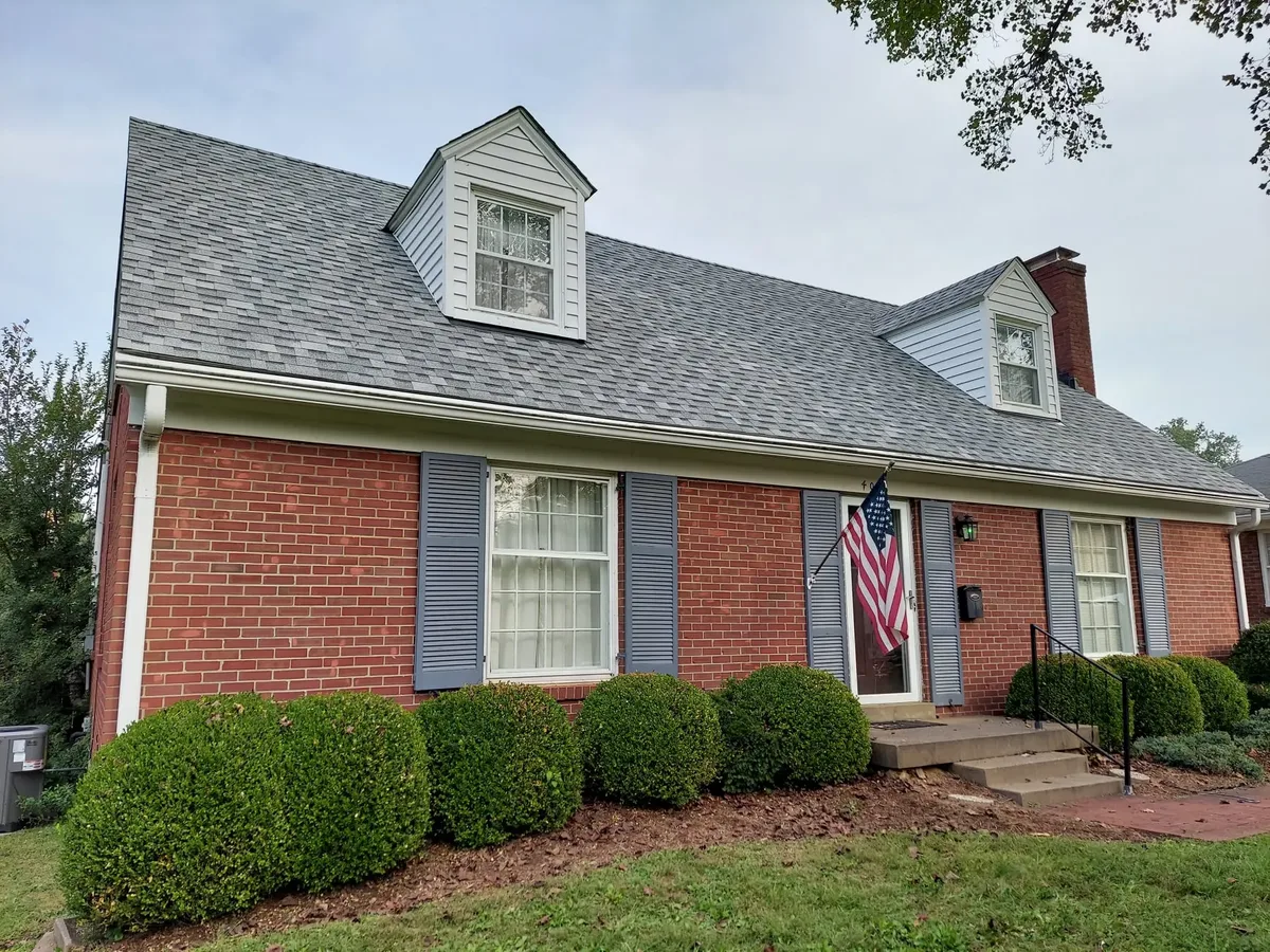 Brick home with a chimney and a shingle roof